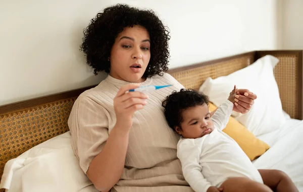 Endişeli Üzgün Afro Amerikan Küçük Çocuklu Annesi Termometreye Bakıyor Bebek — Stok fotoğraf