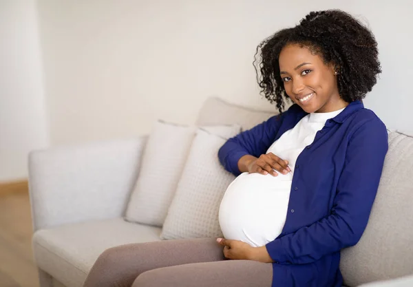 Glad Young African American Pregnant Woman Casual Sits Sofa Touches — Stock Photo, Image
