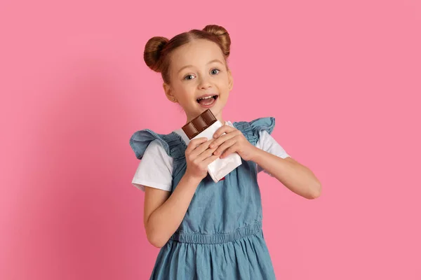 Tatlı Diş Çikolatayı Isıran Kameraya Gülümseyen Sevimli Küçük Kız Stüdyoda — Stok fotoğraf