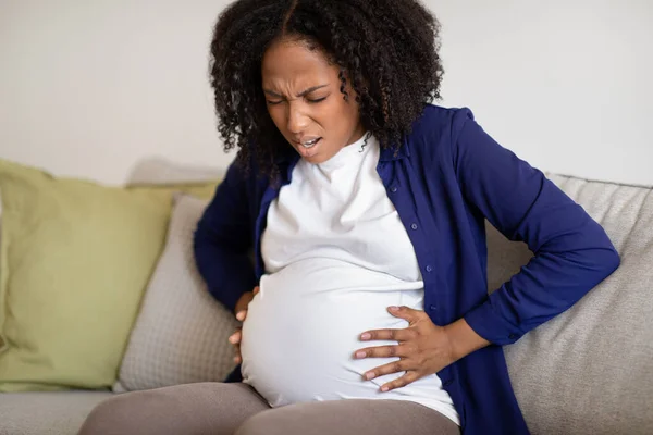 Förtvivlad Ung Afrikansk Amerikansk Gravid Kvinna Sitter Soffan Lider Sammandragningar — Stockfoto