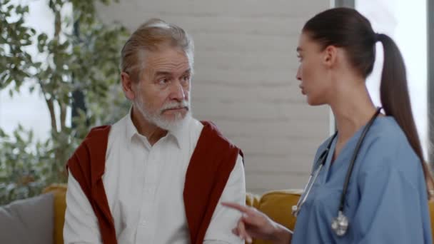 Медицинская Помощь Пожилых Людей Профессиональная Молодая Женщина Медсестра Разговаривает Пожилым — стоковое видео