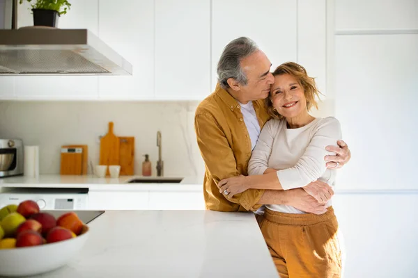 Mutlu Kıdemli Eşler Günlük Kıyafetlerle Kucaklaşıyorlar Rahat Beyaz Mutfakta Birlikte — Stok fotoğraf