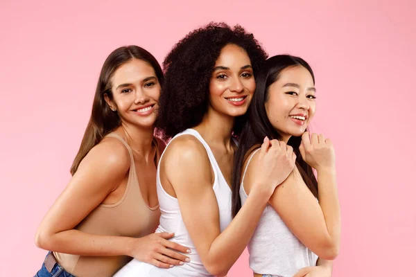 Glücklich Posieren Und Umarmen Drei Unterschiedliche Damen Auf Rosa Studiohintergrund — Stockfoto