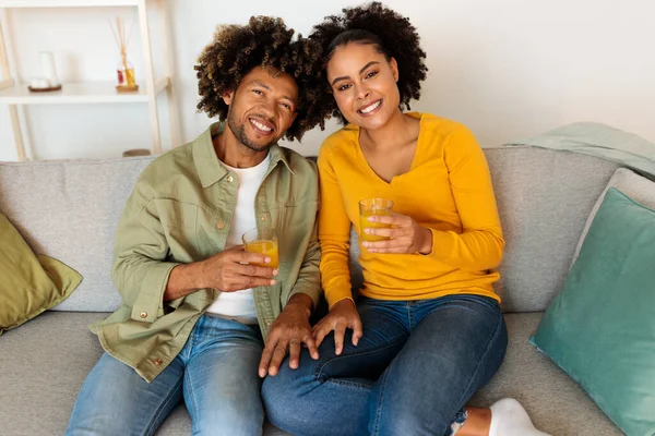 Wesoła Para Afroamerykanów Pijąca Świeży Sok Pomarańczowy Pozująca Okularów Uśmiechnięta — Zdjęcie stockowe