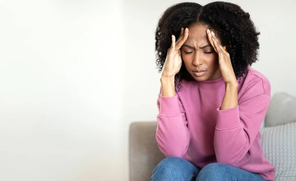 Sorgsen Trött Ung Afrikansk Amerikansk Lockig Kvinna Sitter Soffan Pressar — Stockfoto