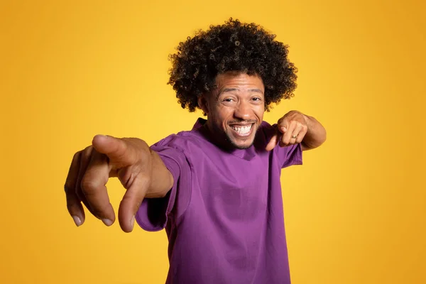 黄色のスタジオの背景にカメラで指を指して紫色のTシャツで興奮した成熟したアフリカ系アメリカ人の巻き男を満足させました あなたの選択とあなたのターン 素晴らしい広告とオファー — ストック写真
