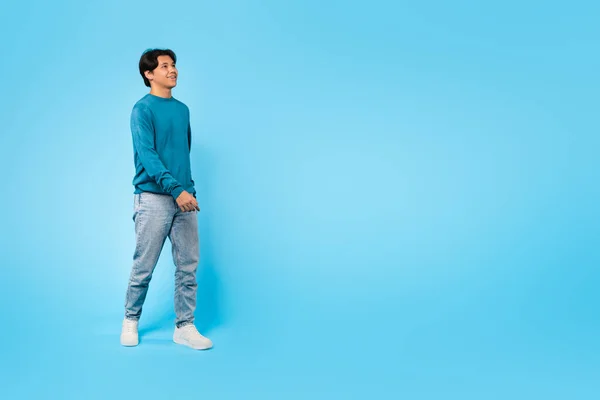 全长拍摄快乐的亚洲少年男子走过蓝色工作室背景 学生投寄近副本空间广告您的报价 广告横幅概念 — 图库照片