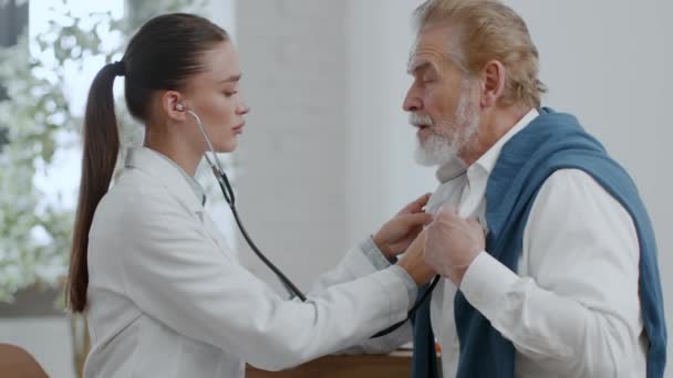 Professionelle Ärztin Überprüft Atmungssystem Eines Älteren Mannes Mit Husten Hört — Stockvideo