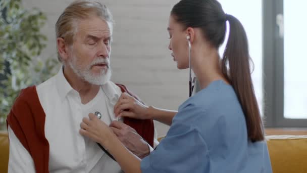 Genç Profesyonel Kadın Doktor Steteskopla Yaşlı Hastanın Nefesini Kontrol Ediyor — Stok video