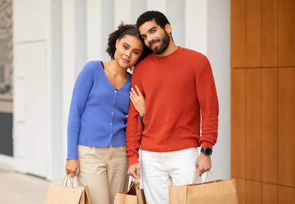 家庭购物服务 心满意足的购物者夫妇带着纸袋和纸袋站在现代商场上 微笑着面对相机 在商店向快乐的顾客开枪 周末销售广告 — 图库照片