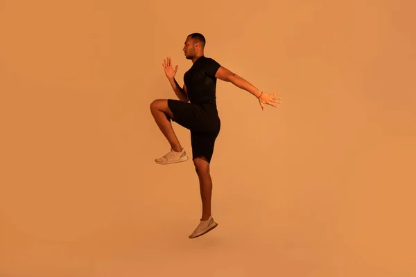 决心的黑人健身男练习做肘关节扭伤或跳跃投出了米色工作室背景 全长拍摄 健康的生活方式 运动和锻炼的概念 — 图库照片