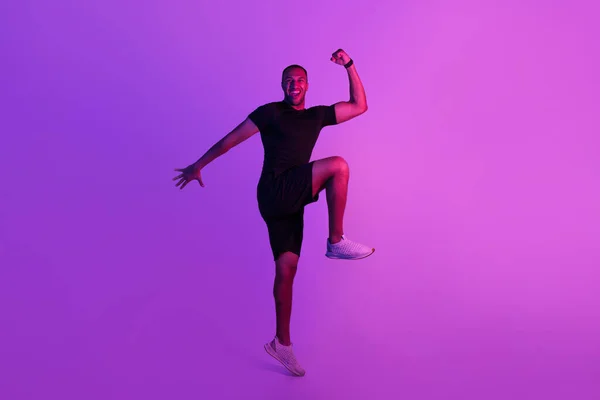 运动和锻炼 在演播室里 快乐地适合黑人跳跃和练习手肘对膝盖笑着在紫色背景下拍照 全身而退健身训练概念 — 图库照片