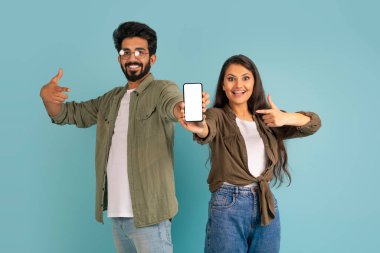 Harika bir anlaşma. Şirin, neşeli, genç, şık Hindu çift yepyeni cep telefonlarını beyaz ekran ile gösteriyorlar. Makyaj yapıp gülümsüyorlar. Renkli bir stüdyo geçmişleri var.