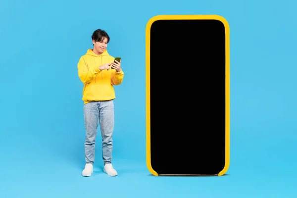 Boldog Koreai Tinédzser Fiú Közel Nagy Mobiltelefon Üres Képernyős Szörfözés — Stock Fotó