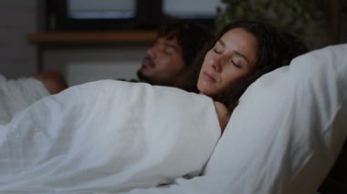 Rahat bir gece uykusu. Erkek arkadaşıyla yatakta uyuyan, yastığı açıp yorganı çeviren, ağır çekimde sarılan, serbest alan genç, huzurlu ortadoğulu kadının yakın portresi.