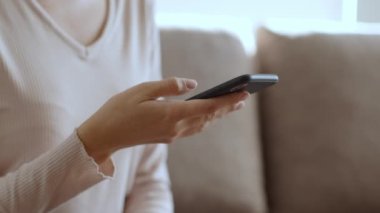 Modern iletişim. Sosyal medyada tanınmayan genç bir bayanın akıllı telefonla internette sörf yaparken yakın plan görüntüsü, çevrimiçi servisin keyfi, yavaş çekim, boş alan