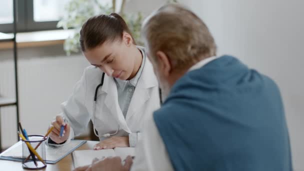 Terapis Geriatrik Wanita Profesional Berkonsultasi Dengan Pasien Pria Senior Klinik — Stok Video