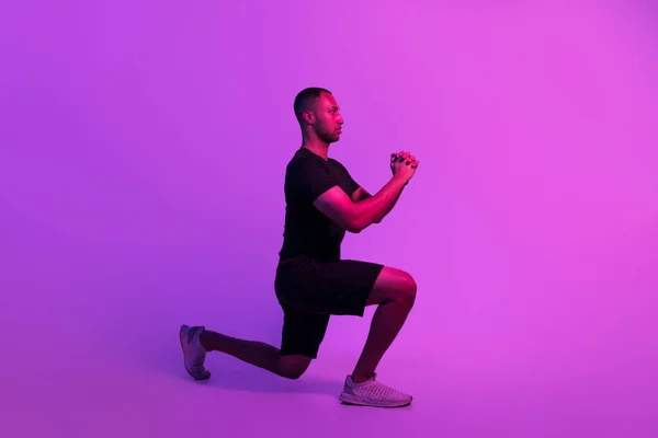 フィットネスワークアウト 紫のスタジオの背景の上に肺を行う運動黒人男性 サイドビュースポーツガイトレーニングのショット脇を見ます フィットウェアを身に着けています スポーツモチベーションコンセプト — ストック写真