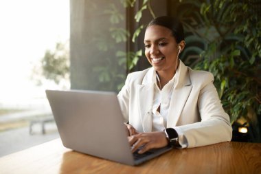 Cihazda buluşuyoruz. Beyaz takım elbiseli pozitif siyah kadın masada oturuyor, kafenin içinde bitkilerin olduğu bir bilgisayarda daktilo yazıyor. Lokantada blog, iş ve iş uzak, başlangıç ve serbest