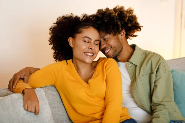 真の愛 触手の額を抱えた公開黒人夫婦が 自宅でソファに座って瞬間を楽しむ 週末には愛の配偶者の絆のショット ロマンチックな関係と愛情 — ストック写真