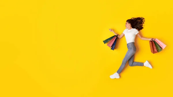 Büyük Indirim Alışveriş Delisi Kadın Alışveriş Torbalarını Havada Gezdiriyor Sarı — Stok fotoğraf
