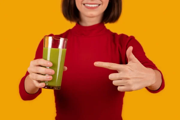 デトックス 健康的なライフスタイルの概念 緑のスムージーと赤の保持ガラスで認識できない女性 健康的なおいしい飲み物を指して トリミング オレンジの背景 — ストック写真