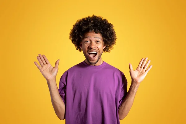 興奮した中年アフリカ系アメリカ人の男性が紫色のTシャツを口を開いて手を上げて 黄色のスタジオの背景に驚きをお楽しみください 素晴らしいニュース 勝利の感情 オファー — ストック写真