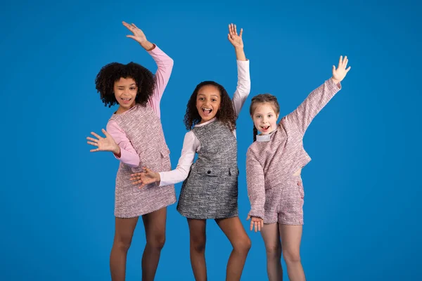 Веселі Багаторасові Дівчатка Розважаються Танцюючи Разом Ізольовано Синьому Фоні Студії — стокове фото