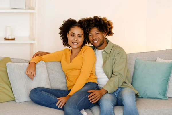Šťastní Afroameričtí Manželé Objímající Pózu Pohovce Doma Usmívající Kameru Mladý — Stock fotografie