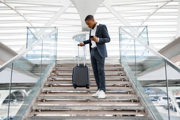 Молодой Черный Бизнесмен Смартфоном Спускающийся Лестнице Терминале Аэропорта Симпатичный Афроамериканец — стоковое фото