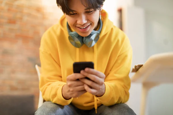 快乐的亚洲青少年男孩通过手机上网 发短信和交流坐在他家里的房间里 持有智能手机的年轻学生在线玩手机游戏 选择性聚焦 — 图库照片