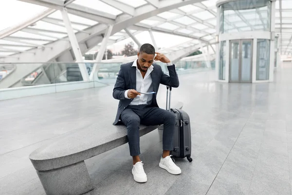 Hombre Negocios Negro Con Maleta Sentado Banco Aeropuerto Mirando Los — Foto de Stock