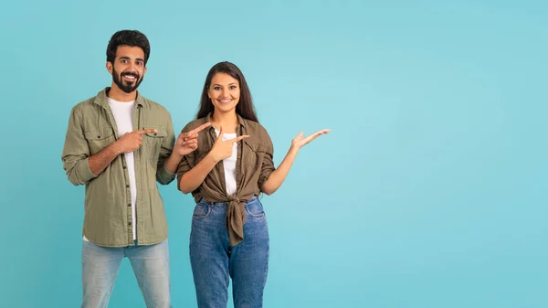 明るく幸せな美しい愛する若いインドのカップルのヒップスターは 広告や笑顔のためのコピースペースを指して 素晴らしいオファー カラフルなスタジオの背景 パノラマを表示 — ストック写真