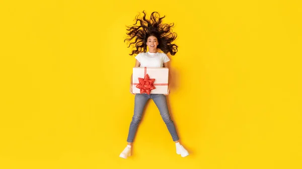 Excited Young Lady Holding Big Gift Box Red Bow Lying — Stock Photo, Image