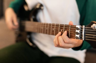 Müzikal Yetenek. Erkek Elleri 'nin elektro gitarda akorlar çalması, enstrüman tutması ve tellere dokunması. Müzik hobisi ve eğlence. Kırpılmış Vuruş, Seçici Odaklanma