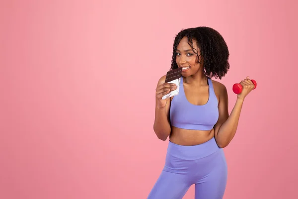 아프리카 미국인젊은 숙녀가 스포츠 맹세를 손으로 바보같은 초콜릿을 분홍색 스튜디오 — 스톡 사진