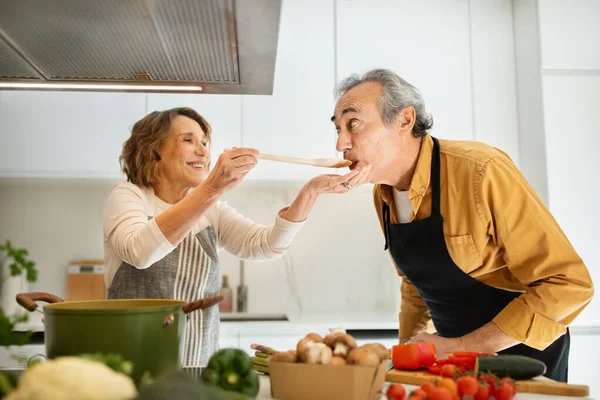 Glada Äldre Makar Provsmaka Mat Kvinna Ger Sin Man Att — Stockfoto