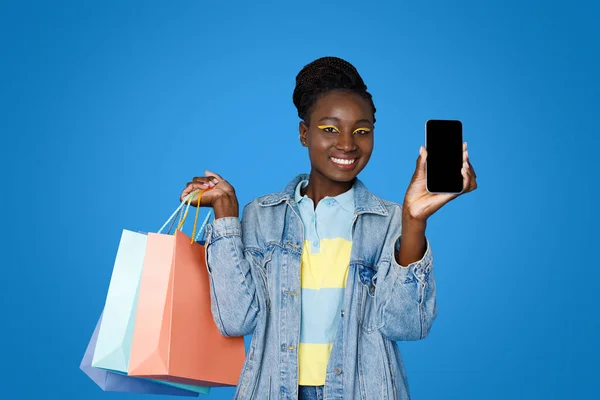 Улыбается Красивая Молодая Черная Женщина Повседневной Моды Показывая Покупки Телефон — стоковое фото