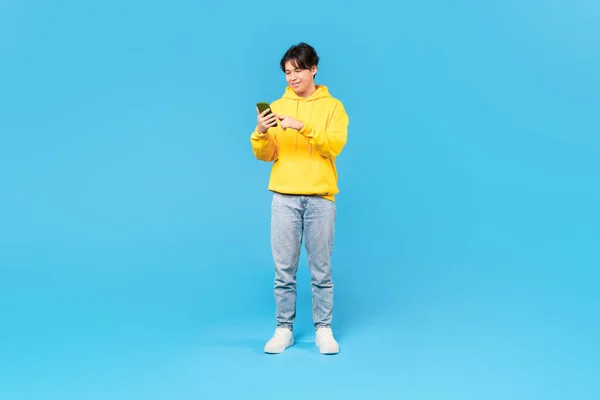 2018 Smiling Asian Teen Guy Texting Cellphone Surfing Internet Scrolling — 스톡 사진
