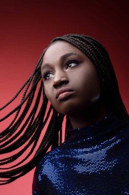 Siyahi Kadın 'ın Sequin Party' deki yakın plan portresi örgülü saçlarıyla, moda fotoğrafında güzel Afro-Amerikan kadın modelinin sanatsal makyajı ve burun delici bakışları.