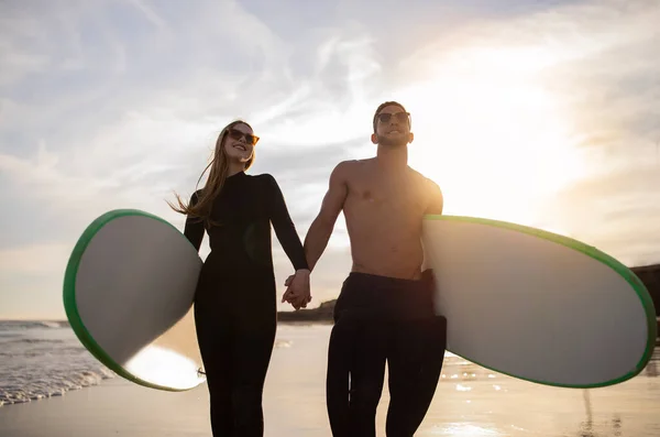 Romantyczna Młoda Para Spacerująca Deskami Surfingowymi Sunset Beach Trzymająca Się — Zdjęcie stockowe