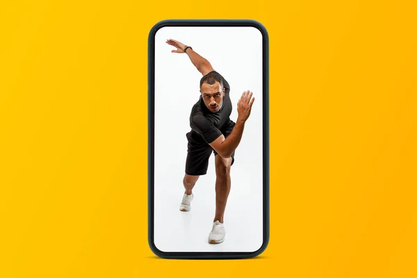 黄色のスタジオの背景 コラージュ フル長さに隔離された電話画面上で実行されているスポーツウェアのプロの若い黒人男性 プロスポーツ ボディケアと体重減少 — ストック写真