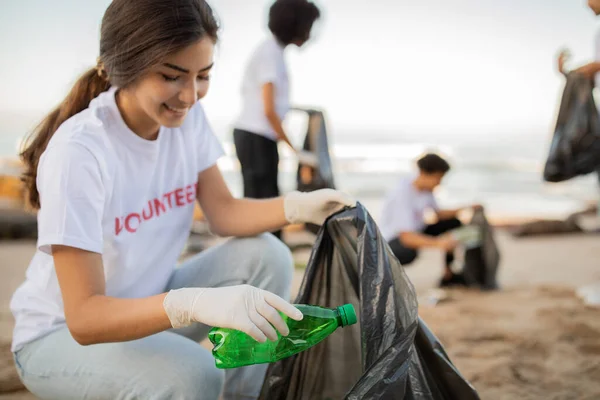快乐的年轻人志愿者和戴着手套的亚洲女人带着垃圾袋清理海滩上的垃圾 环境保护 保护地球 地球日和海洋污染 — 图库照片