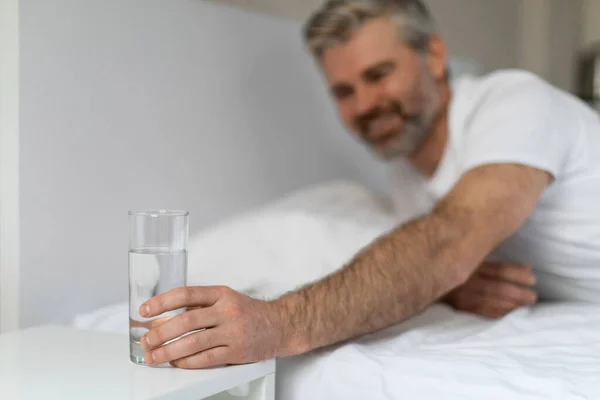Hidratálás Mosolygó Boldog Jóképű Középkorú Férfi Fehér Pólóban Feküdt Ágyban — Stock Fotó