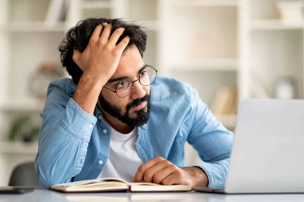 思想的缺乏 厌倦了的印度男性自由职业者在家里工作的时候看着笔记本电脑屏幕 烦躁不安的东方男人坐在电脑前 创造力有问题 衣衫褴褛 — 图库照片