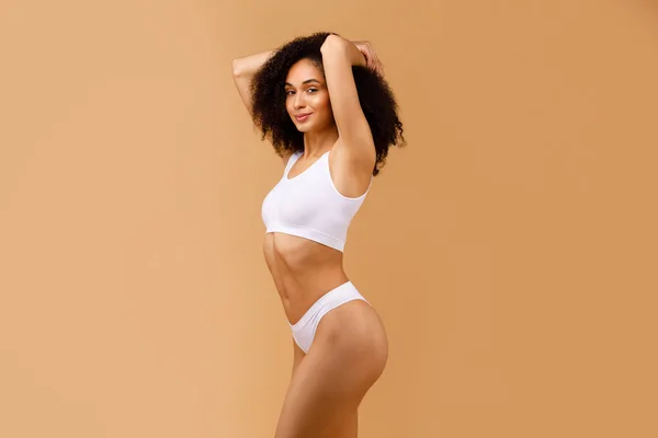 stock image Skincare and radiance. Glowing young black lady with perfect body figure exemplifying the importance of self-care routines, showcasing the results of sport and healthy lifestyle