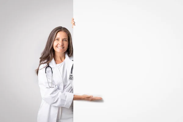 나이든 여의사는 의학적 설계를 빈자리가 위에서 효과적 광고를 — 스톡 사진