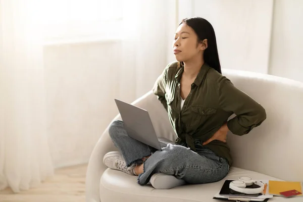 Unavená Mladá Asiatka Volné Noze Sedící Gauči Laptopem Klíně Doma — Stock fotografie