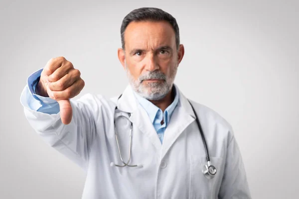 Vážně Sebevědomý Evropský Stařec Doktor Bílém Kabátě Stetoskopem Ukazují Palec — Stock fotografie