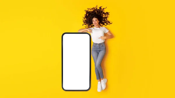 Kocaman Telefonu Boş Ekranla Işaret Eden Neşeli Bayan Sarı Arka — Stok fotoğraf